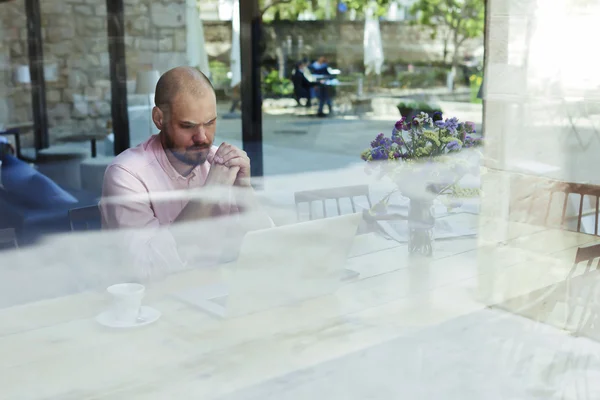 Businessman working on laptop in coffee shop