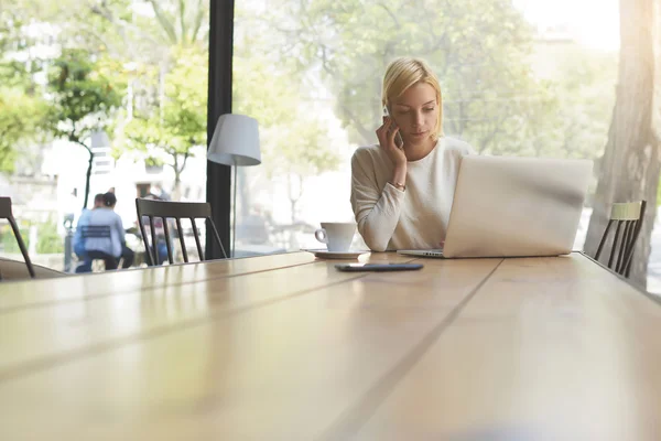 Woman having smartphone conversation in cafe