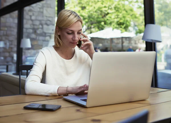 Young businesswoman working on net-book in cafe