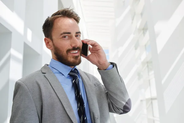 Businessman talking on mobile phone in office