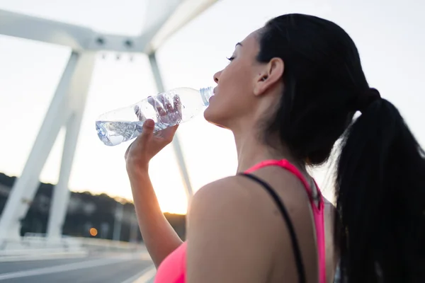 Woman refreshing with energy drink after jog