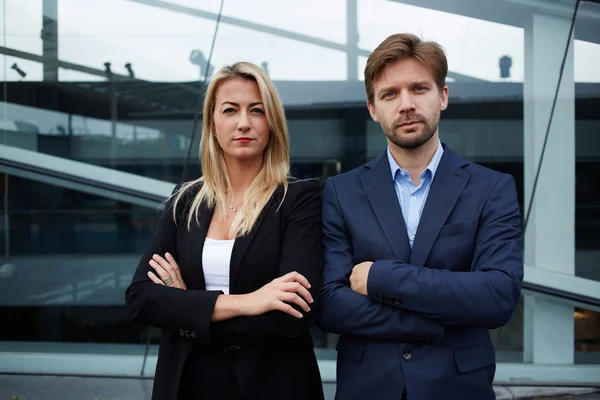 Business partners posing near office building