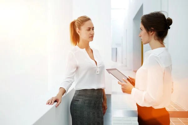 Businesswomen discussing ideas on digital tablet