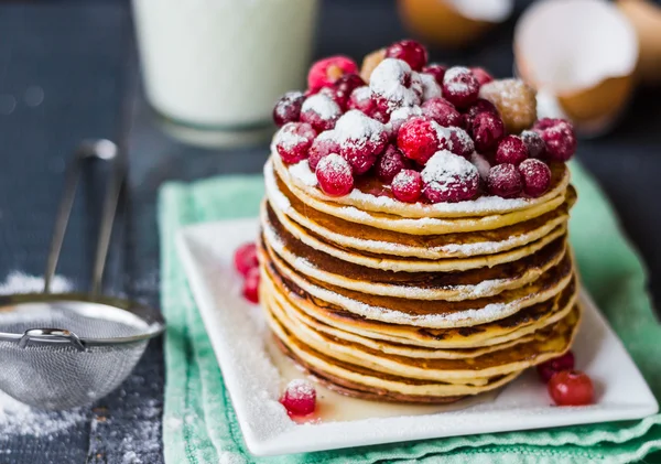 Pancake with cranberries, raspberries, honey and powdered sugar