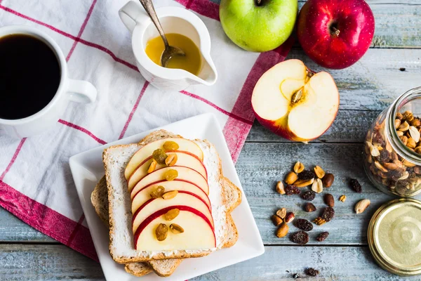 Sandwich with cheese, apple and dried fruit, a cup of coffee