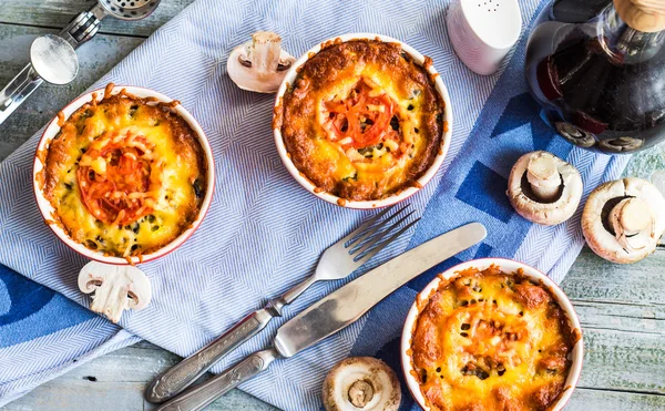 Baked mushroom julienne with tomato and cheese in red pots