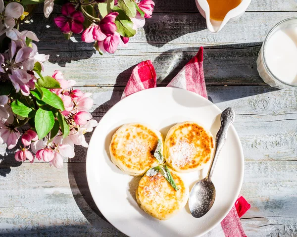 Cottage cheese pancakes with mint and powdered sugar, flowers,to