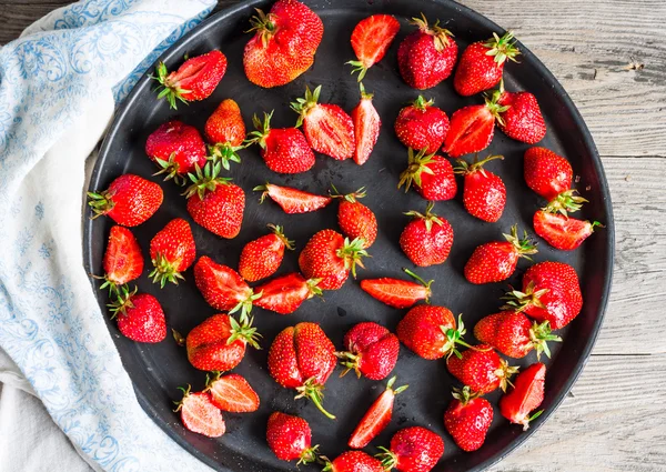 Fresh juicy strawberries on a black tray, top view