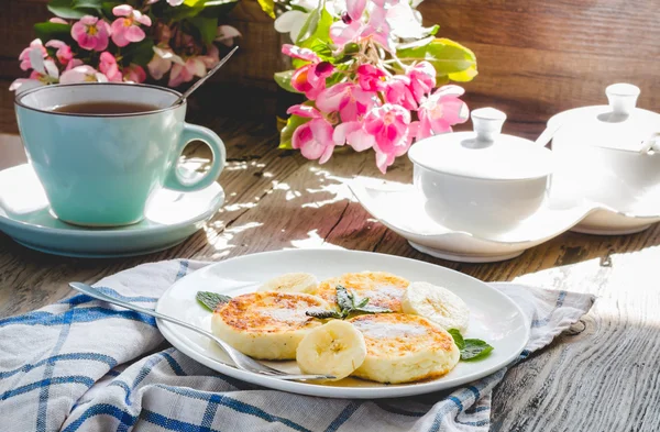 Pancakes from cottage cheese  with banana, powdered sugar and mi