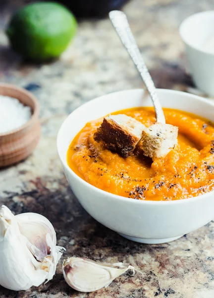 Autumn pumpkin soup in a white plate, vegan dinner