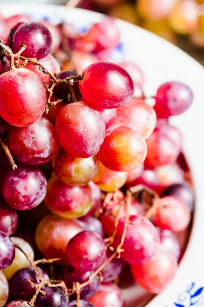 Fresh red grapes on the plate, raw fruits, whole plant foods