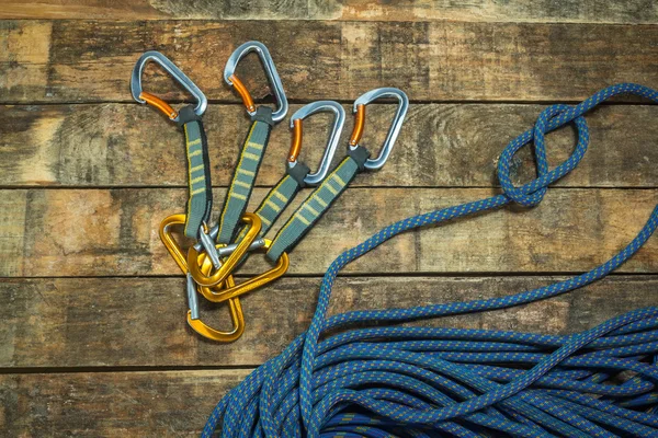 Climbing rope and carabiner on wooden boards