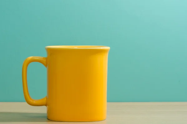 Yellow mug on wooden table