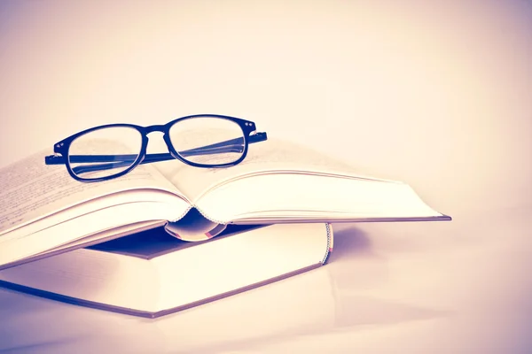 Black rimmed glasses placed on opened book