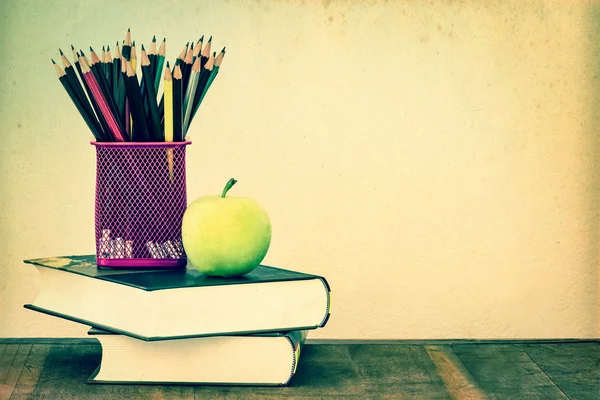 Green apple with pencil box on wooden table in concept of study