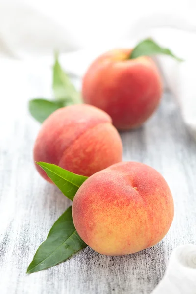 Peaches on rustic table.