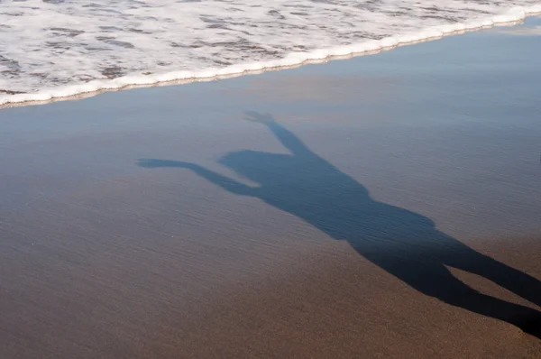 Shadow of young woman on the beach