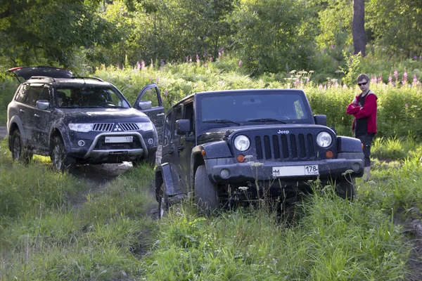Russia, Karelia, July 16, 2015: Photo of jeep Wrangler and Mitsubishi Pajero Sport on the Karelian forest road in Russia. Wrangler is a compact four wheel drive off road and sport utility vehicle, manufactured by American automaker Chrysler.