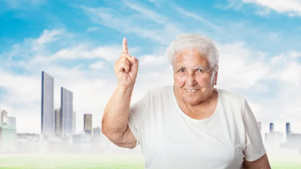 Old woman pointing up with finger