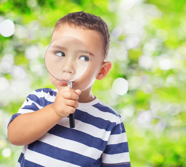 Kid looking through magnifying glass