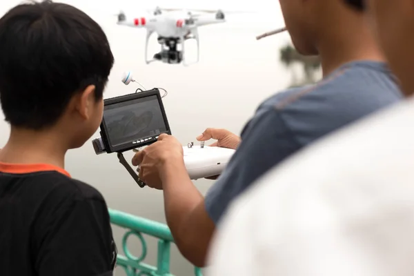 Father and son controlling a remote drone helicopter with LCD sc