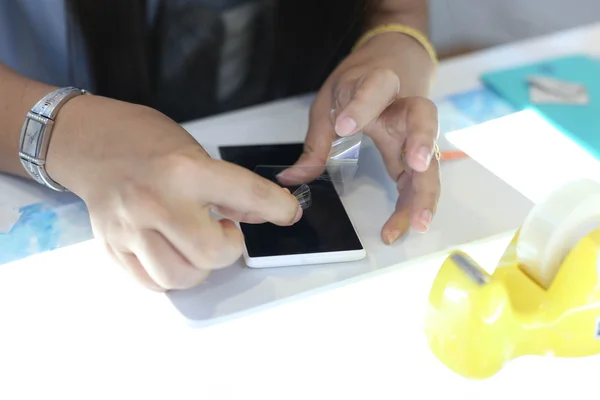 Woman applying a screen protector on an cellphone