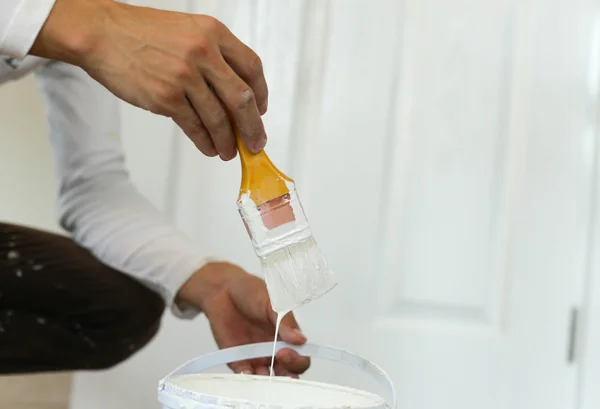 Painter hand holding yellow brush painting