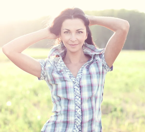 Girl in plaid shirt summer  meadow, concept the idea of happiness brunette rest nature