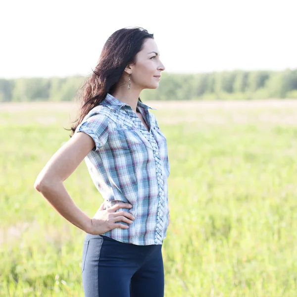 Girl in plaid shirt summer  meadow, concept the idea of happiness brunette rest nature