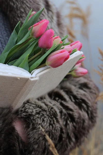 Bouquet of pink tulips in female hands