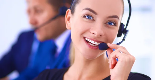 Portrait of beautiful business woman in headphones smiling with colleagues in background