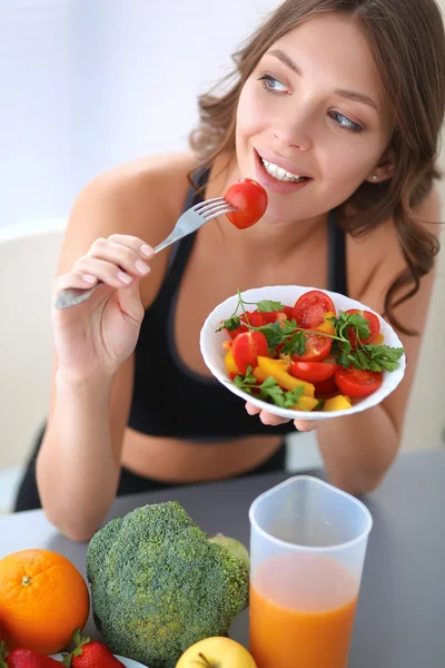 Portrait of smiling young woman with vegetarian vegetable salad