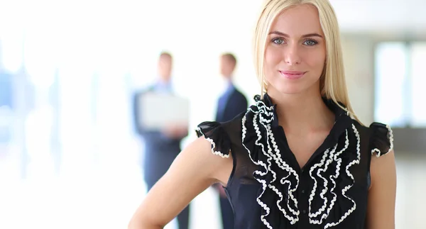Business woman standing in foreground in office