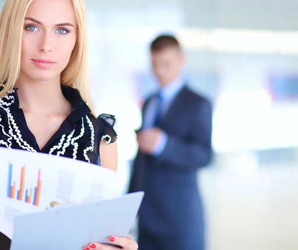 Business woman standing in foreground with a folder in her hands