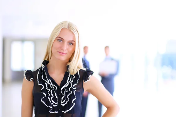 Business woman standing in foreground in office