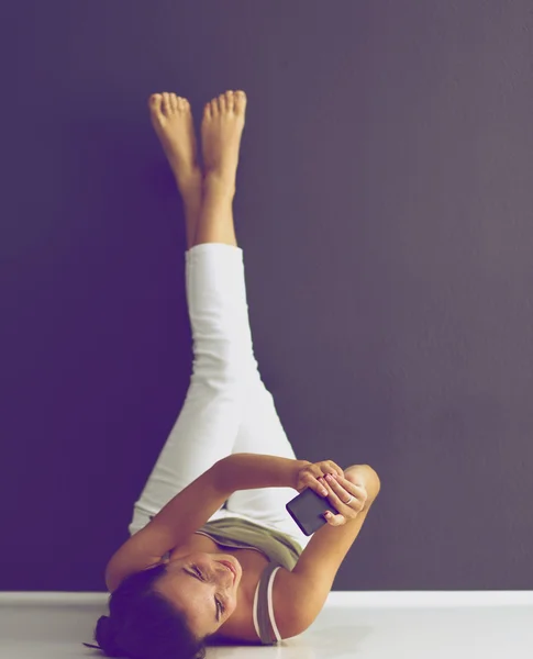 A woman lying on the floor with legs up