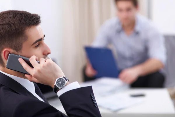 Business people talking on phone at office