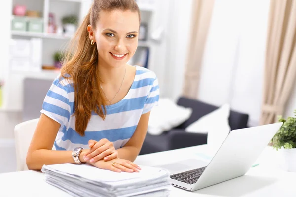 Indoor picture of smiling woman with documents