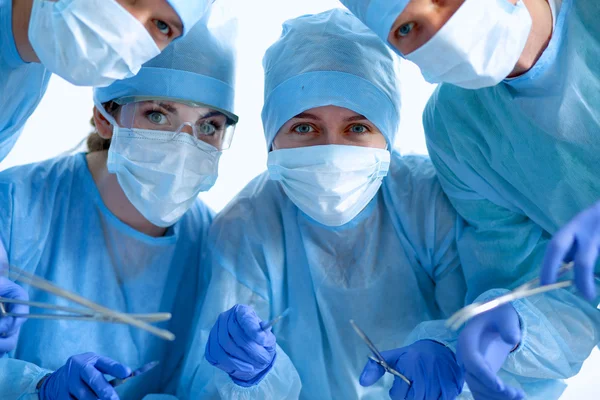 Below view of surgeons holding medical instruments in hands