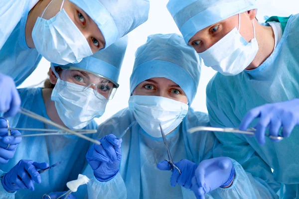 Below view of surgeons holding medical instruments in hands