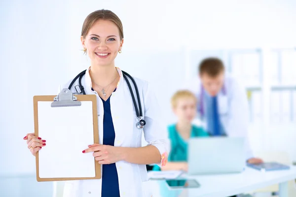 Attractive female doctor with folder in front of medical group