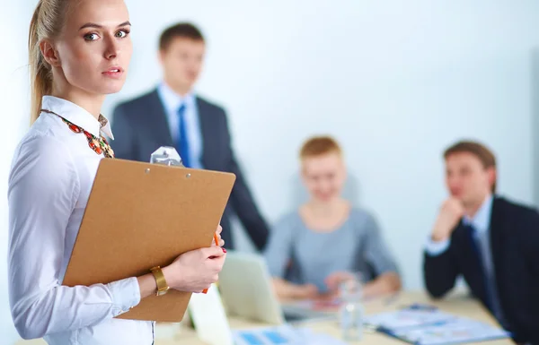 Portrait of a young woman working at office standing with folder