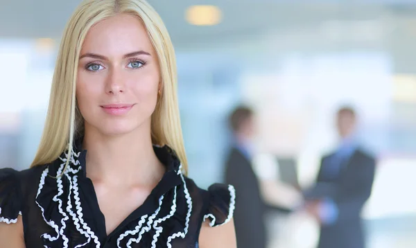 Business woman standing in foreground  in office