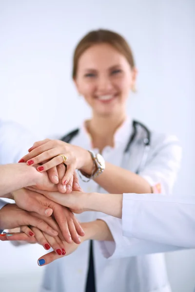 Team of doctors putting their hands together in a symbol of unity