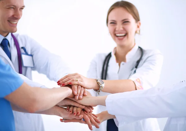 Team of doctors putting their hands together in a symbol of unity