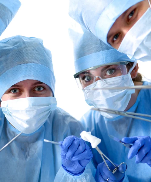 Below view of surgeons holding medical instruments in hands