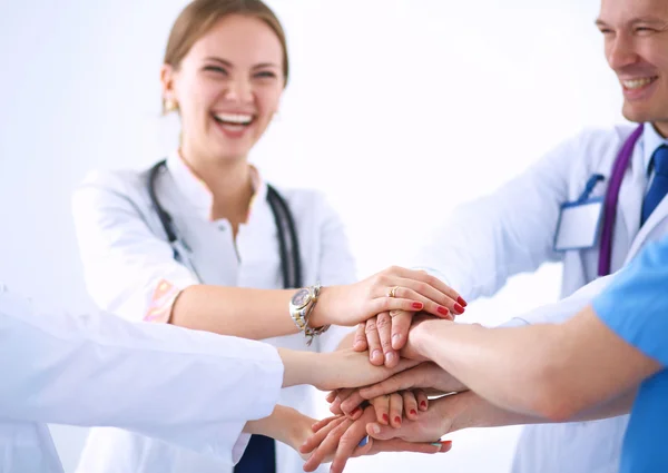 Team of doctors putting their hands together in a symbol of unity