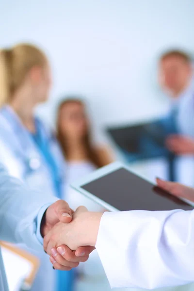 Young medical people handshaking at office