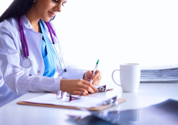 Female doctor sitting on the desk with paper and working