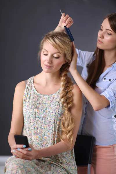 Young woman hairdresser do hairstyle girl in salon